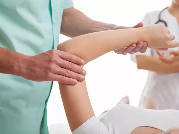 An orthopedic specialist examining a patient’s elbow
